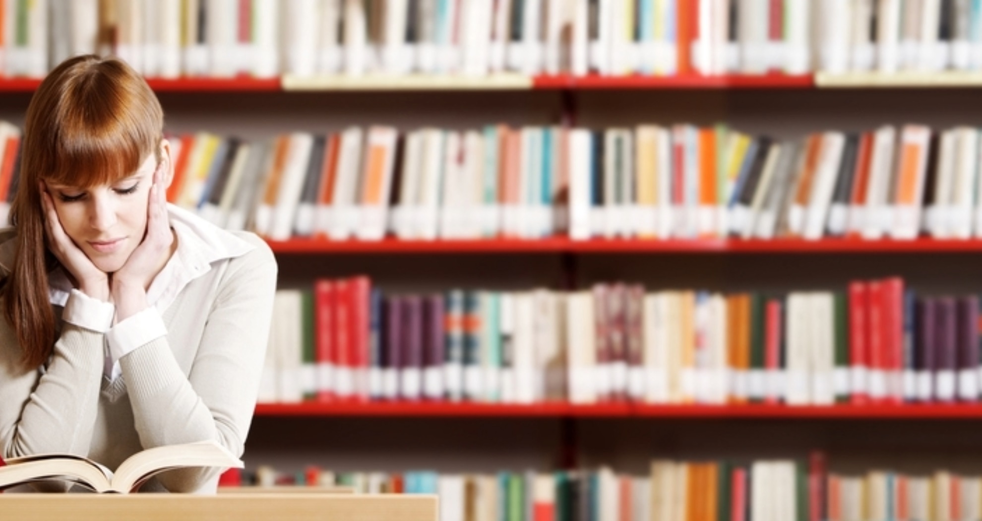 Woman reading a book in a library