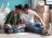 A couple on the bedroom floor of their new home choosing a paint colour for the walls.