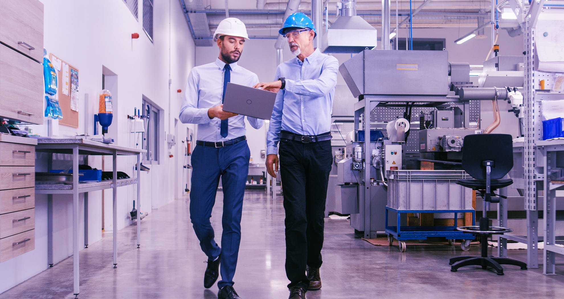 two men walking in a factory