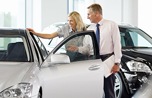 Couple standing beside new car