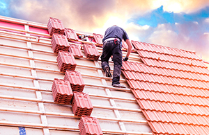 Man laying slates on a roof