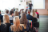 A rear-view of students sitting down in class being lectured.