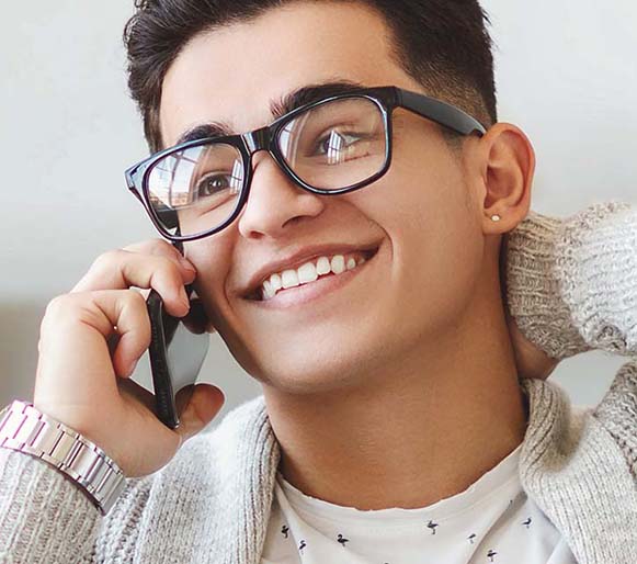 A happy young guy doing his AIB banking over the phone.